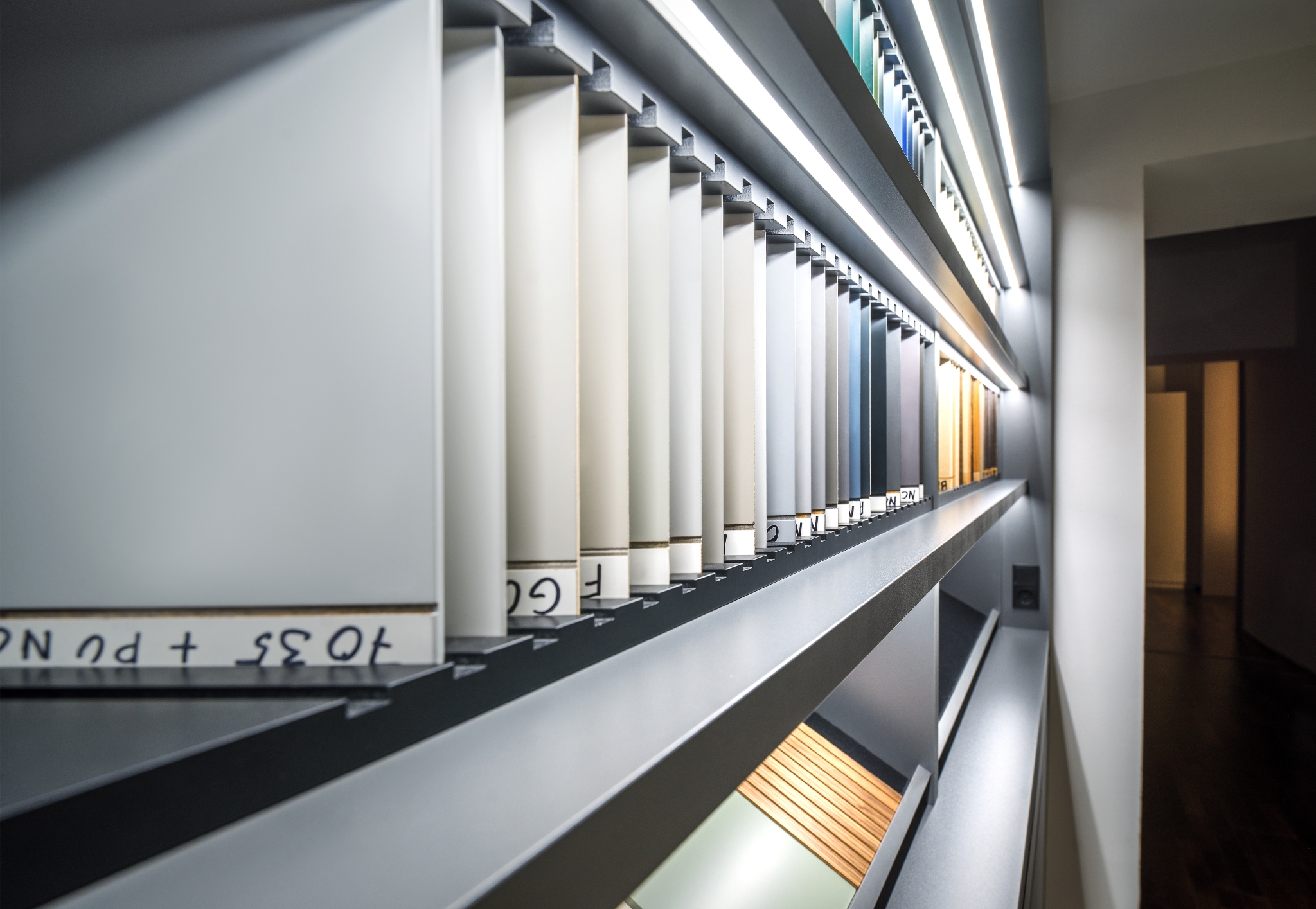 Eine moderne Bibliothek mit abstraktem Design und einem Korridor mit auf einzigartigen, abgewinkelten Regalen aufgereihten Büchern, die zu einer futuristischen Erkundung der Literatur einladen.